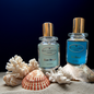 Two 30 ml perfume bottles, Élan Rouge and Le Récif by Milliarda Cannes, displayed on sand with coral and seashells, inspired by the Mediterranean sea.