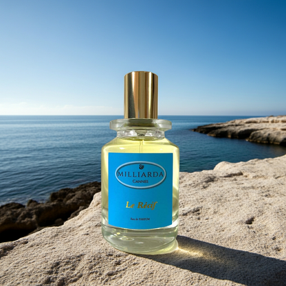 Le Récif luxury perfume photographed on a cliff with a sunlit sea backdrop, a crisp fragrance of citrus and mineral woods inspired by the raw beauty of Australia’s coral reefs.