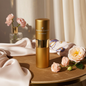 Maison Canine Veil Parfumé Mini gold dog perfume bottle on table with roses and silk background