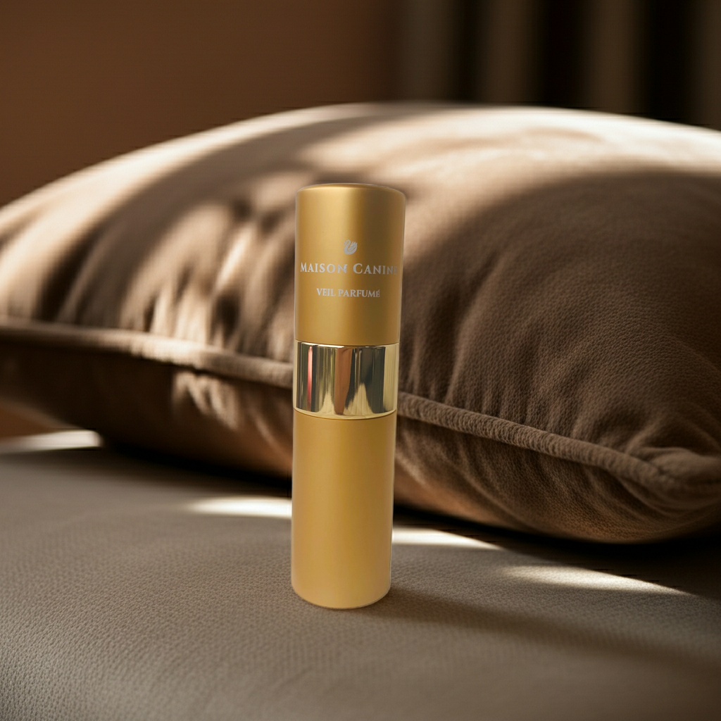 Maison Canine Veil Parfumé Mini gold dog fragrance bottle on dark brown cushion with atomiser closed